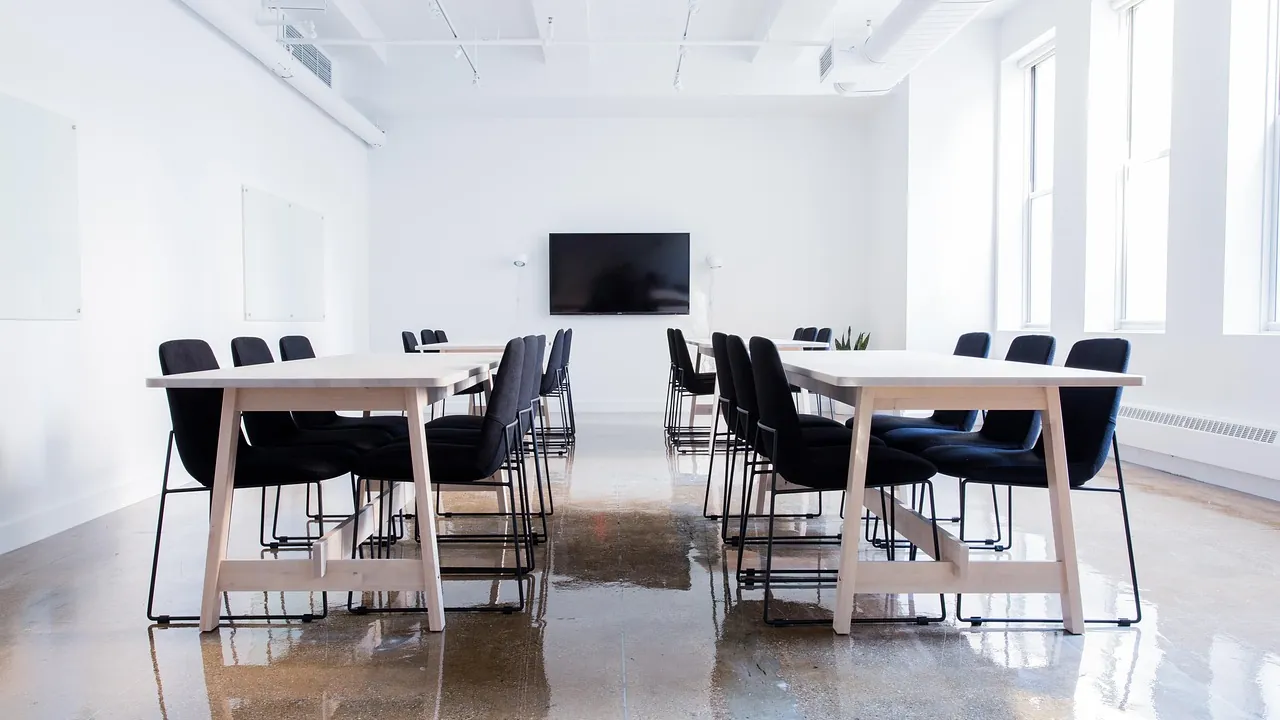 Une salle de séminaire vide, tables et chaises alignées