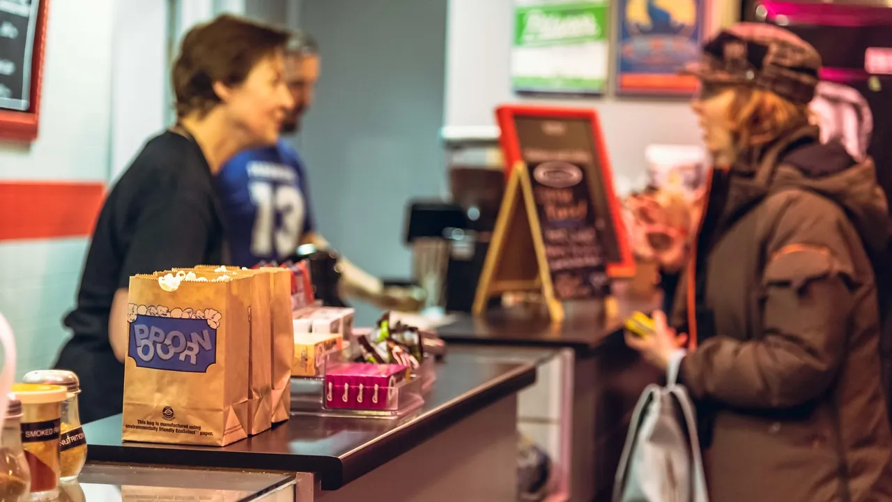 Une cliente et une vendeuse échangent au comptoir d’un commerce